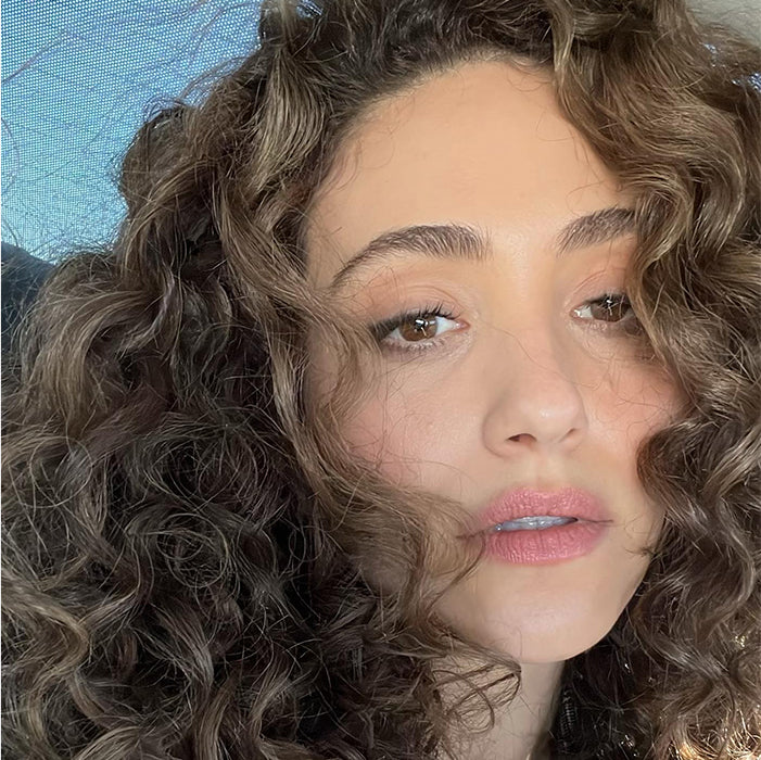 Close-up portrait with curly hair and soft, natural brows by Maggie Moon